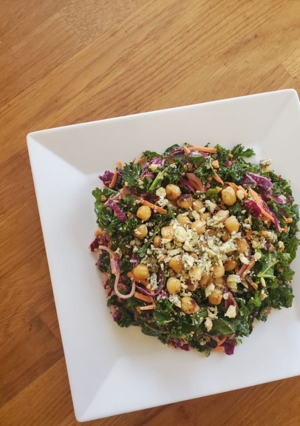 A satisfyingly crunchy kale salad with carrots, cabbage, and crunchy quinoa all tossed with buffalo sauce and blue cheese